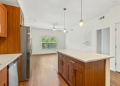 Thumbnail 43 of 57 - a kitchen with an island and a stainless steel refrigerator