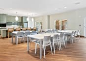 Thumbnail 5 of 57 - a dining room with white tables and chairs and a kitchen