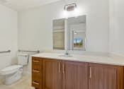 Thumbnail 47 of 57 - a bathroom with a toilet and a sink and a mirror