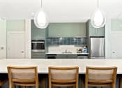 Thumbnail 6 of 57 - a modern kitchen with a large island with wooden chairs