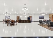 Thumbnail 9 of 12 - an expansive community room with tables, chairs, a tv, fooseball table and kitchenette at Horicon School Apartments