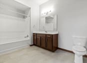 Thumbnail 7 of 12 - a bathroom with a toilet sink and shower and a mirror at Horicon School Apartments