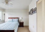 Thumbnail 10 of 18 - bedroom with large window, ceiling fan, closet, and model furnishings