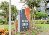 Thumbnail 13 of 18 - Orlando Cloisters sign in front of senior apartments surrounded by lush landscaping