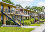Thumbnail 15 of 37 - a row of yellow houses with stairs and palm trees
