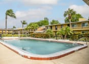 Thumbnail 4 of 37 - a swimming pool in front of a hotel with palm trees