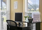 Thumbnail 13 of 37 - a desk with a computer and a chair in front of a window