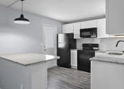 Thumbnail 18 of 37 - a kitchen with white cabinets and black appliances