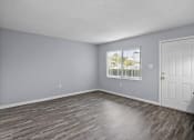 Thumbnail 22 of 37 - an empty living room with wood floors and a window