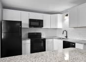 Thumbnail 20 of 37 - a kitchen with white cabinets and black appliances