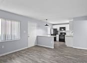 Thumbnail 16 of 37 - an open kitchen and living room with a wood floor and white walls