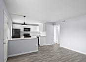 Thumbnail 21 of 37 - the living room and kitchen of an apartment with white walls and wood flooring