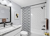 Thumbnail 6 of 37 - A bathroom with a black and white shower curtain.