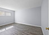 Thumbnail 23 of 37 - an empty living room with wood flooring and a window