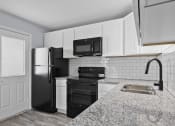 Thumbnail 19 of 37 - a kitchen with black appliances and white cabinets