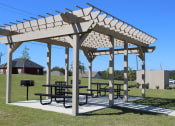 Thumbnail 12 of 18 - Large Pergola on a concrete slab with picnic tables and grilling stations
