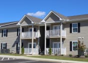 Thumbnail 16 of 18 - Apartments with balconies, neat breezeway, trim lawns, and well-kept sidewalks