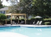Thumbnail 11 of 18 - a swimming pool with chaise lounge chairs and a pergola at Stillwater at Grandview Cove
