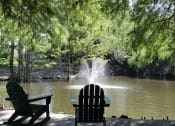 Thumbnail 15 of 18 - a fountain in a pond with two adirondack chairs at Stillwater at Grandview Cove