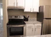 Thumbnail 17 of 18 - Stillwater apartment kitchen with white cabinets and stainless steel appliances