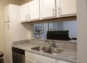 Thumbnail 16 of 18 - Stillwater apartment kitchen with white cabinets and granite countertops