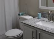 Thumbnail 18 of 18 - Stillwater apartments bathroom with granite countertops, toilet, and shower curtain