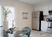 Thumbnail 10 of 30 - kitchen with stainless steel appliances and dining room with hardwood-inspired flooring  at Huntsville Landing Apartments, Huntsville, AL