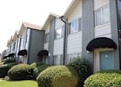 Thumbnail 7 of 30 - apartments painted white and grey with teal doors and black awnings and mature landscaping  at Huntsville Landing Apartments, Alabama, 35806