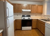 Thumbnail 13 of 24 - wooden cabinets and white appliances in a home at Algonquin Manor