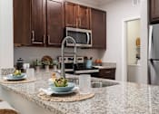 Thumbnail 17 of 40 - a kitchen with granite counter tops and stainless steel appliances