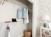Thumbnail 25 of 40 - a closet with clothes hanging on the wall and a closet door with shoes on it