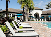Thumbnail 2 of 40 - a pool with lounge chairs and a building in the background