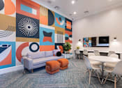 Thumbnail 12 of 40 - a room with a couch table and chairs and a wall with a mural