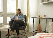 Thumbnail 16 of 30 - woman enjoying some coffee and sitting by large windows in living room