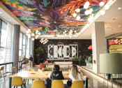 Thumbnail 2 of 42 - lobby with tables & chairs, games, and large ceiling mural at Lake Nona Pixon, Orlando, FL, 32827