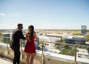 Thumbnail 17 of 42 - man and women on sky lounge deck overlooking downtown lake nona at Lake Nona Pixon, Orlando