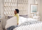 Thumbnail 13 of 42 - Woman waking up in comfortable bed at spacious LandonHouse