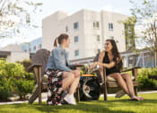 Thumbnail 38 of 42 - two women in Adirondack chairs on the amenity deck at Lake Nona Pixon, Orlando, Florida