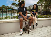 Thumbnail 2 of 30 - two people sitting on low wall by pool with dog on a leash