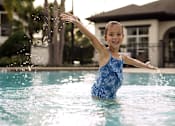 Thumbnail 5 of 40 - a little girl playing in the water in a pool