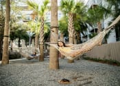 Thumbnail 5 of 42 - Two people relaxing in the hammocks at LandonHouse in Lake Nona, Orlando, FL 32827