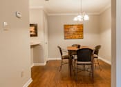 Thumbnail 21 of 33 - A dining room with a wooden table and chairs.