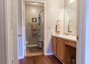 Thumbnail 12 of 33 - A bathroom with a towel hanging on the shower curtain.