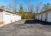 Thumbnail 6 of 33 - A parking lot with a few buildings and trees in the background.