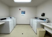 Thumbnail 24 of 24 - a group of washers and dryers in the laundry center at Algonquin Manor