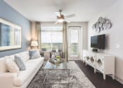 Thumbnail 15 of 42 - Comfortable living room with accent wall and large windows  at LandonHouse Apartments in Lake Nona