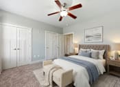 Thumbnail 2 of 15 - A bedroom with a large bed and a ceiling fan.