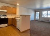 Thumbnail 11 of 24 - a spacious kitchen and living room with appliances, cabinets, and carpeting