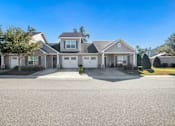 Thumbnail 3 of 12 - A row of houses with driveways in front.