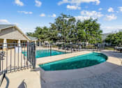 Thumbnail 12 of 12 - A swimming pool surrounded by a fence and trees.